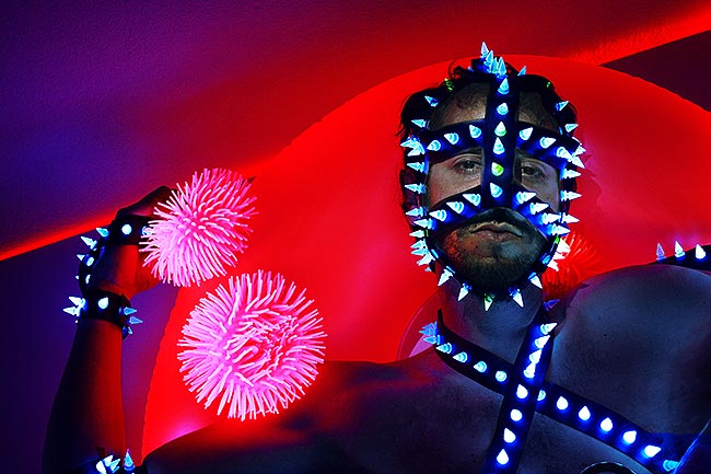 BDSM face mask with spikes glowing under UV light